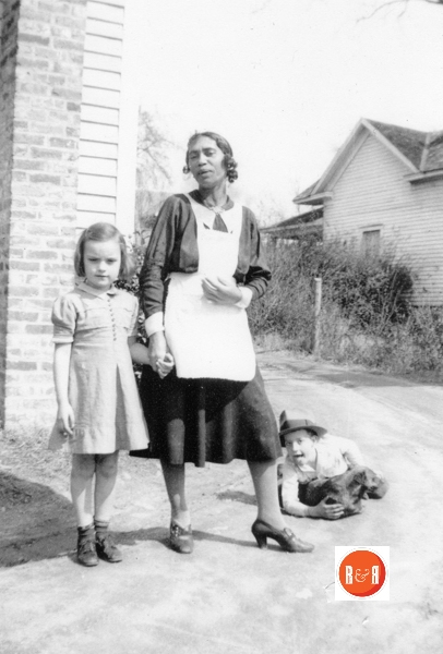 Domestic cook Ms. Betty Carter who worked for the Moore family and Helen Moore (left) and George Moore (rt). Brownie was the Moore family dog. The home to the right – background Ester Strong.