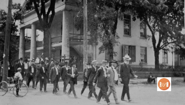 Masons marching to Mr. A.D. Hood’s funeral on 6/15/1915. This image is following the fire and re-construction of the building. [Courtesy of the Van Center Collection]