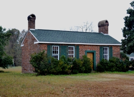 The original brick kitchen stands at the rear of the home.