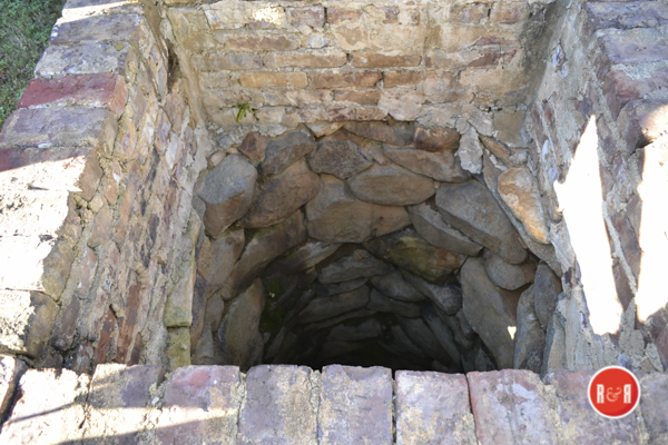Rock lined open well in the front yard of the historic home.