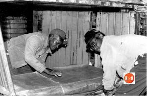 J.D. Parks and friend wrapping a bale of cotton for shipping.