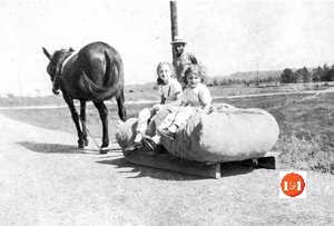 Sarah Jane and Ginger Limehouse riding atop the cotton sled on the way to Papa Flaud Curry’s barn.