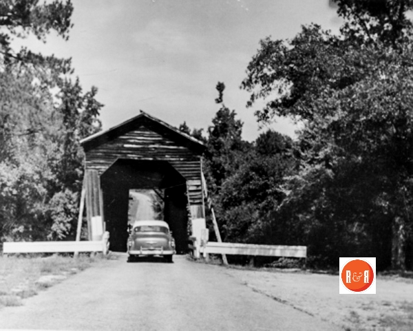 The historic covered bridge near the church. Image courtesy of the FFHS & Museum – Niesler Collection, ca. 1959
Long Cane Creek Bridge in McCormick County spans the historic creek of that name in what is now part of Sumter National Forest. It is three miles west of Troy, in the comer of Abbeville County, which town is almost obscured by historical markers. It was built in 1892 by a prosperous planter of the area, John E. Bradley, a relative of the late, beloved Dr. Frank W. Bradley of the University of South Carolina. Not far away is the mass grave of thirty settlers who were killed by the Cherokees, February 1, 1760, when 150 of them were overtaken by 100 braves in the Cherokee war, as they were trying to escape to Augusta. (Information from: Names in South Carolina by C.H. Neuffer, Published by the S.C. Dept. of English, USC)