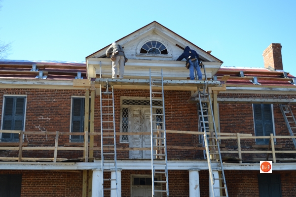 Workman on the second level porch and pediment – 2014.