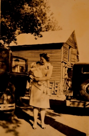 Beck Strait holds Cotton Howell as an infant at 1830 Holland Road. Notice the cotton house in the background remains a promiment feature of the property.