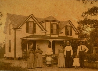 The house with family members standing for their picture in the early 20th century, the Hope family!