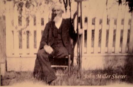 John Miller Sherer, a Confederate veteran pictured outside of his picket fenced yard – date unknown.