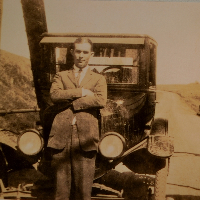 Paul Ferguson standing in front of his automobile, circa 1915.