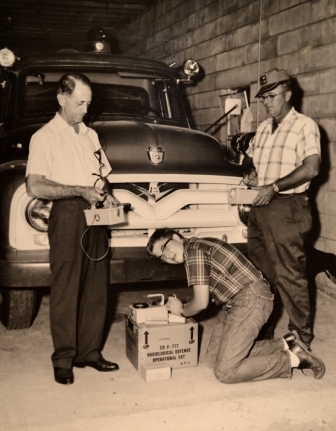 John Hartness, Sr., (Rt), Frank Duncan, Sr., (Lt), and John Hartness, Jr., inspecting radiation equipment in 1978 at the Bullock’s Creek Fire Department