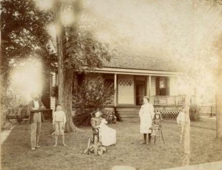 Juan Poag family  home (near Oakdale School), of York County prior to moving to Rock Hill, S.C. [The picture of the family in front of the farm house is, left to right, William Juan Poag, Robert Oates Poag, William’s wife Dora Eleanor Oates Poag holding Annie Reid Poag, Mary Elizabeth (Miss Bessie) Poag standing next to Sara Louise (Louise) Poag Huey, and James Pressley (Jim) Poag half-behind a tree. Annie Reid was born on May 14, 1898, so the picture would have been taken later that year. William J. Poag died in 1906 and never lived in the house on Johnston Street. All 5 children went to college, the men to Clemson and the women to Winthrop. Miss Bessie was the 10th grade teacher at Winthrop Training School for 50 years. Robert moved to New York state after graduation and his descendants still live there. Annie Reid lived most of her life in Asheville, NC where she taught public school. Jim and Louise lived most of their lives in Rock Hill.] Information courtesy of Coleman Poag, Jr. – 2015