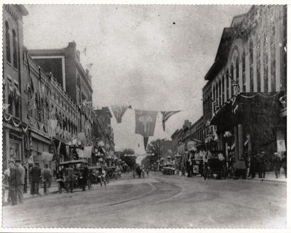 View of East Main Street at the corner of Trade looking up the street with the Roddey Building on the left and the Carolina Hotel on the right.