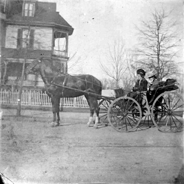 Members of the Friedheim family ride down East Main Street. The J.W. Roddey home is pictured in the background.