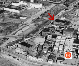 The arrow points to the corner of East White St., and North Trade. The commercial strip along North Trade ran parallel to the railroad down to Main Street. AFLLC Collection